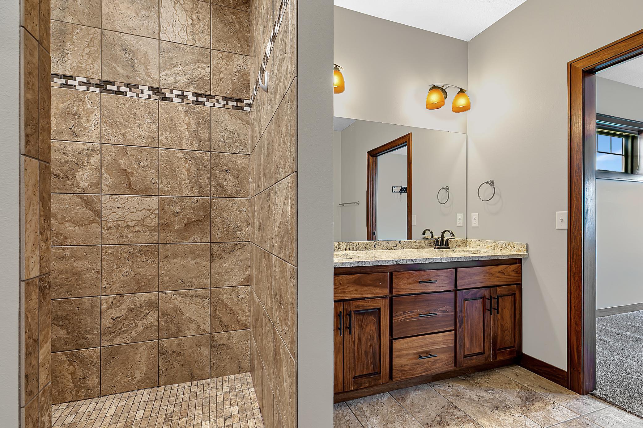 The shower features tiled floors and shower surround.