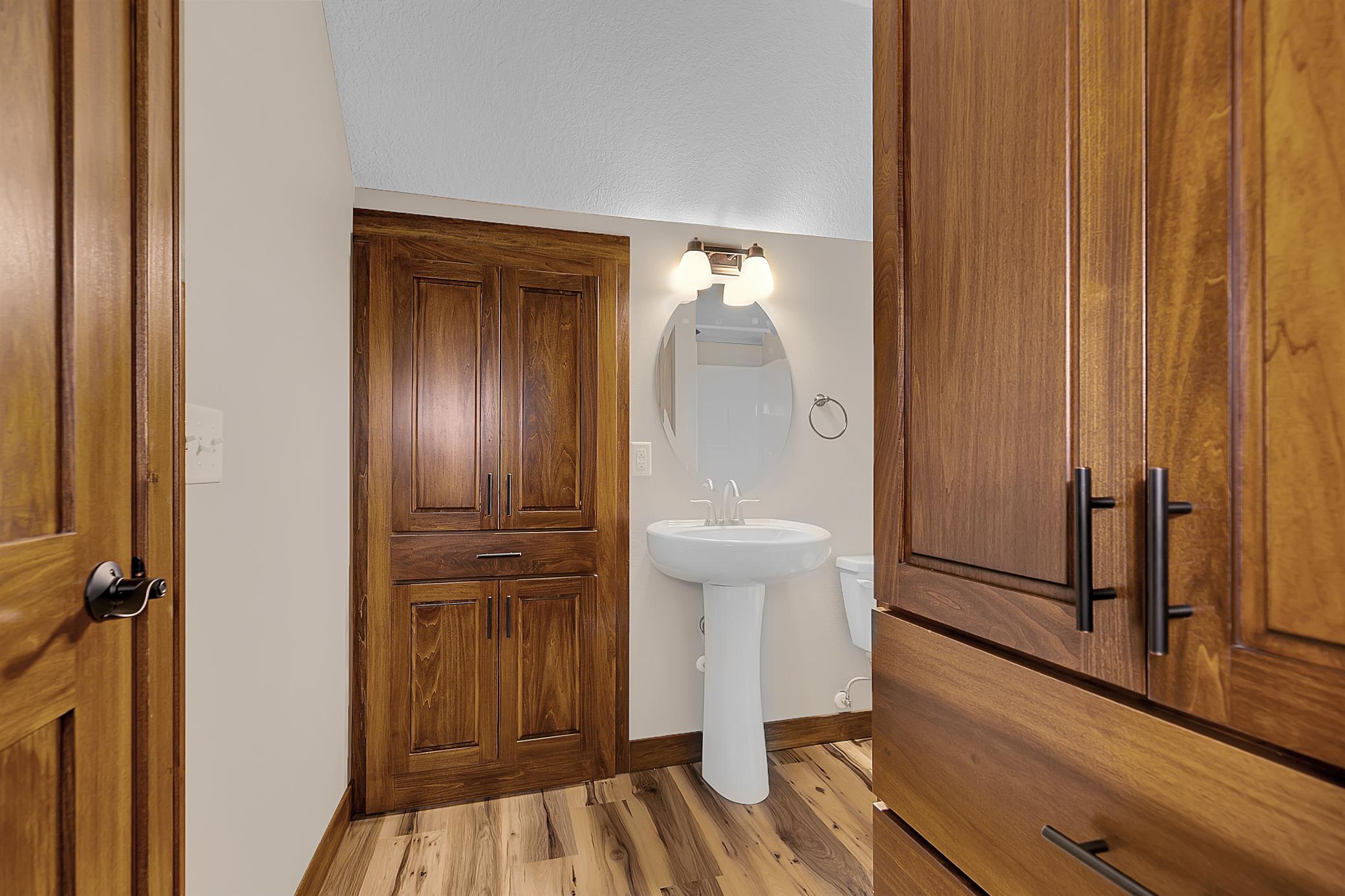 The bathroom also features a pedestal sink and built-in linen closet.