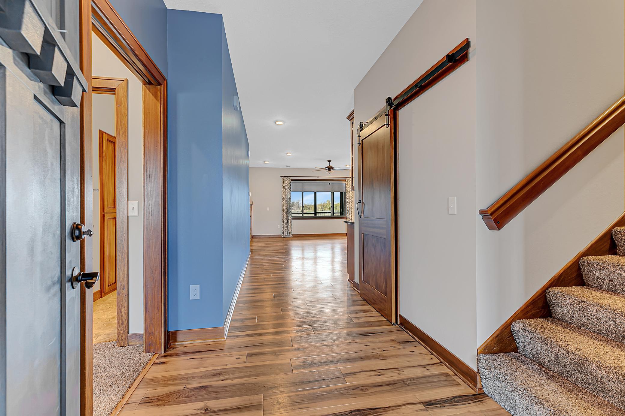 Back down on the main level, a spacious foyer greets you, featuring a stylish barn-door closet and a seamless flow into the heart of the home.