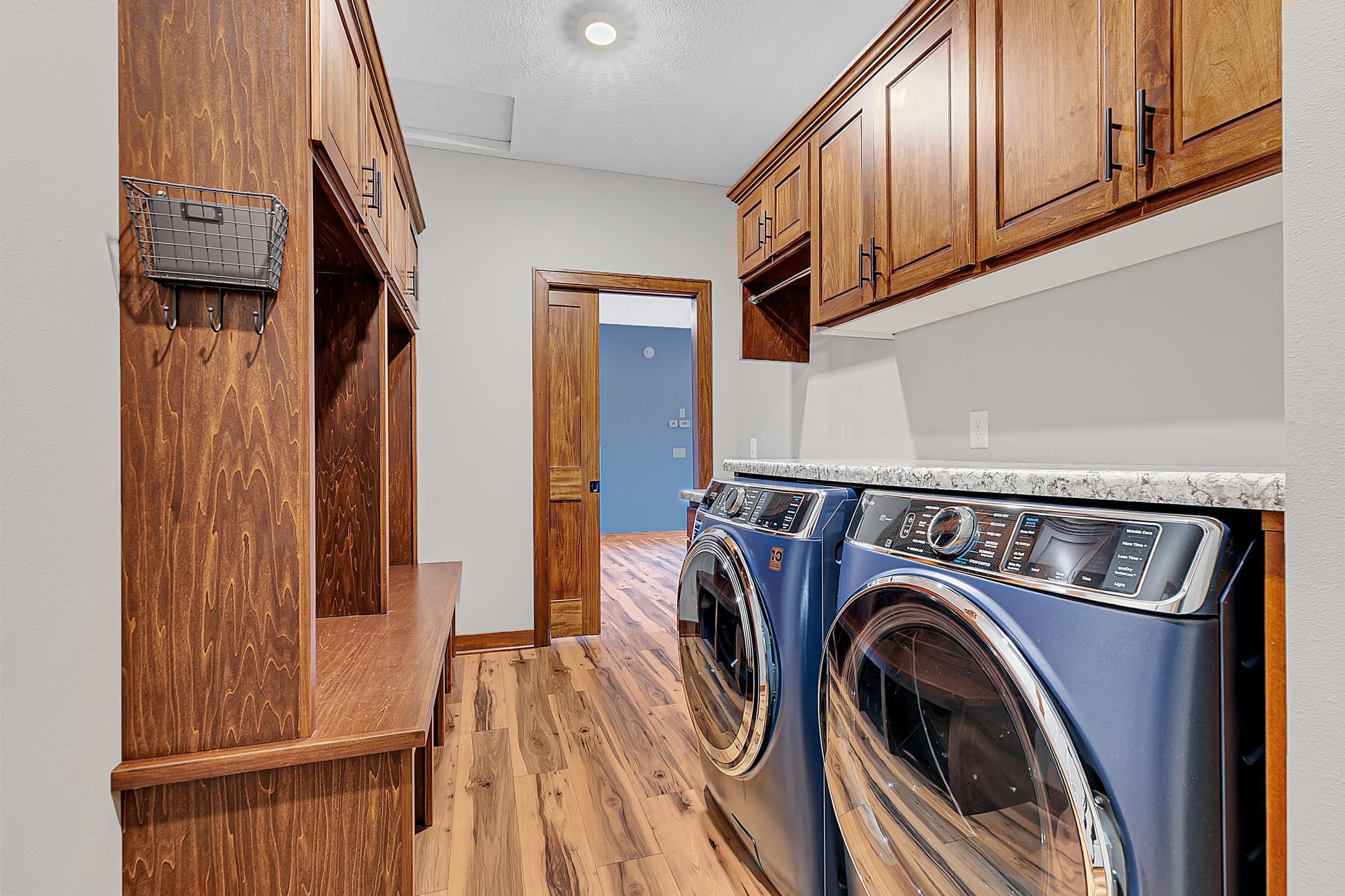 The thoughtfully designed laundry and mudroom area includes a new front-load GE Profile washer and dryer, a utility sink, custom cabinetry, and a folding counter.