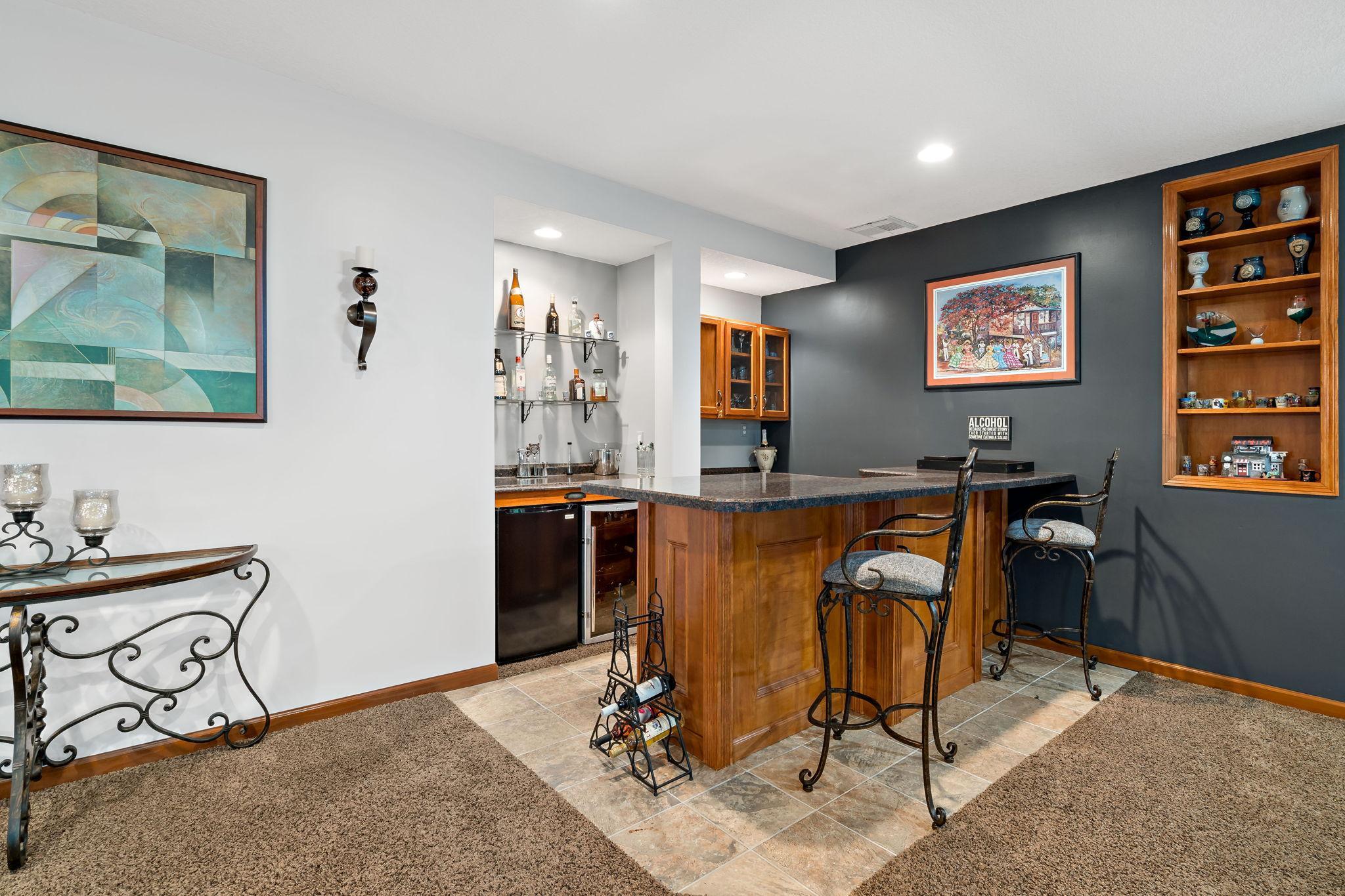 Great wet bar setup with wine fridge and storage for plenty cocktail making necessities!