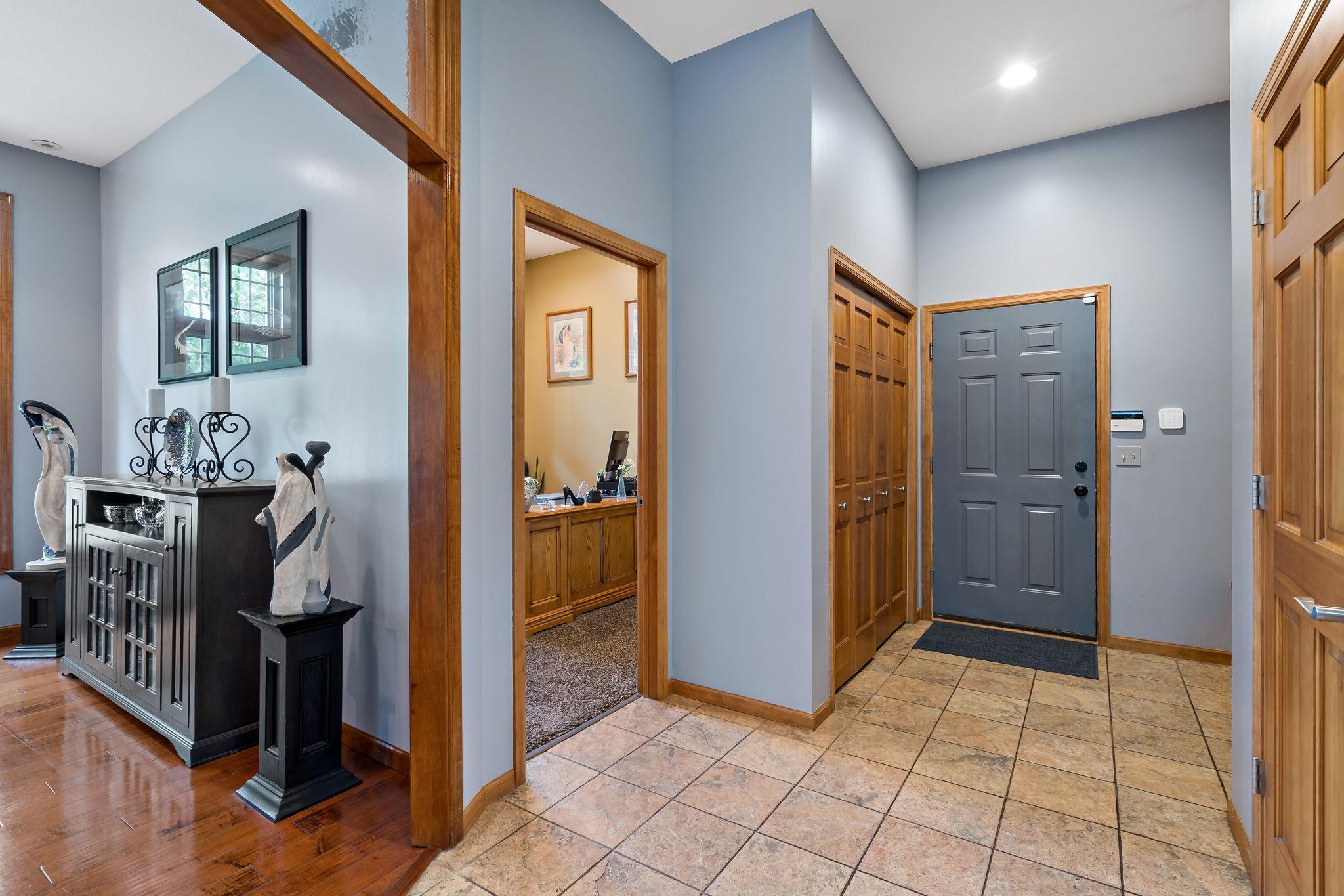 Large entrance from the garage with a closet and bench for storage.