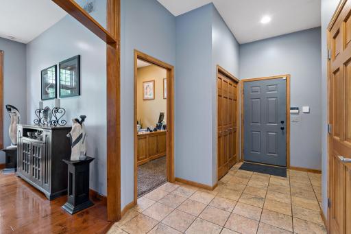 Large entrance from the garage with a closet and bench for storage.