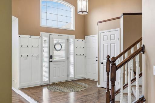 The impressive two-story foyer offers a spacious and welcoming entry, highlighted by a large window above the front door that fills the space with natural light.
