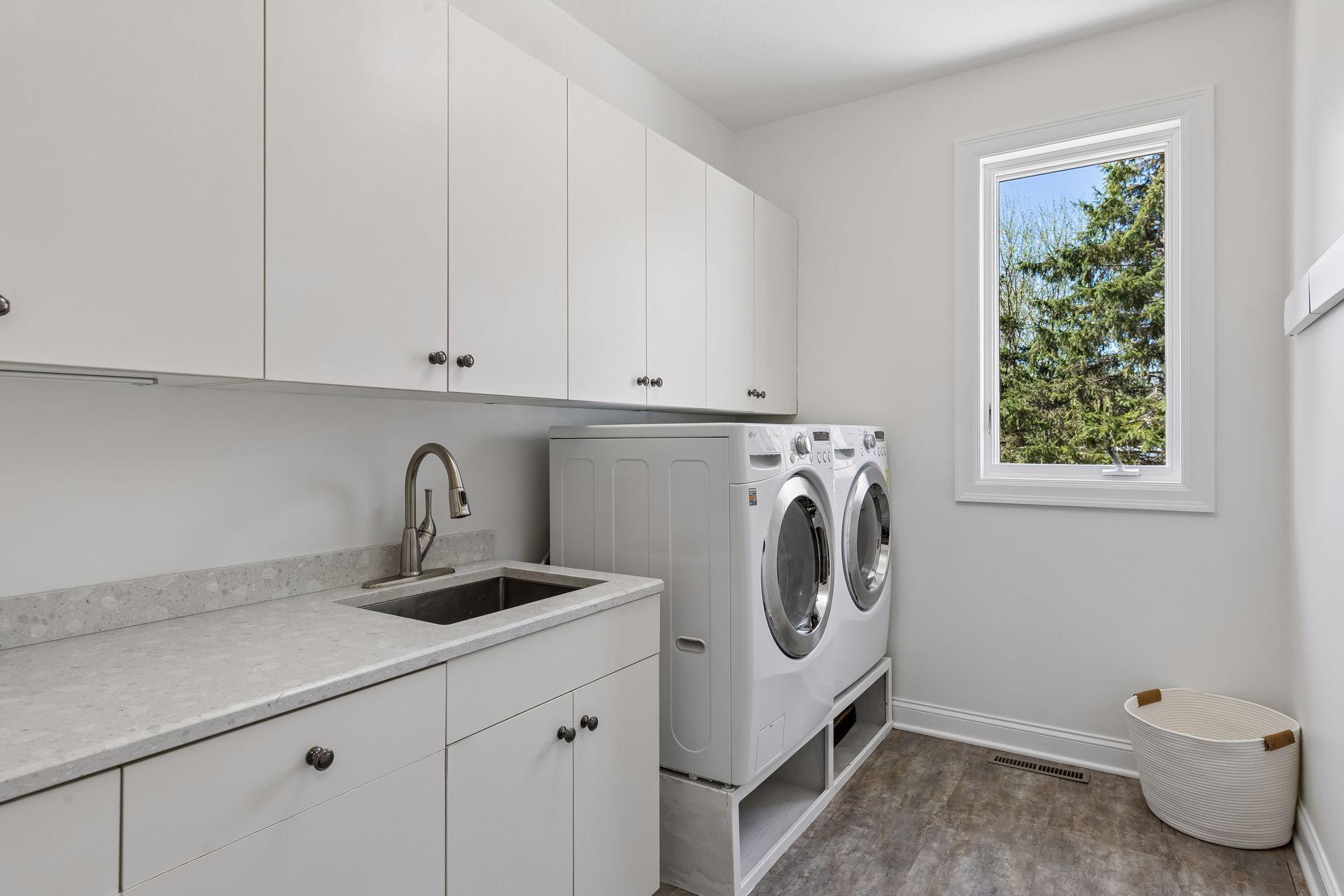 Laundry room with quartz countertop and front loader machines