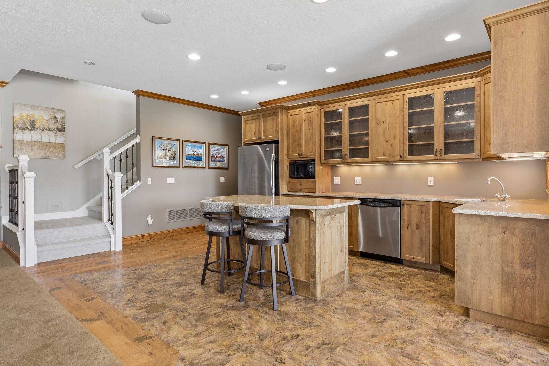 Lower-level kitchen/bar area with tons of cabinets, dishwasher, microwave, and refrigerator.