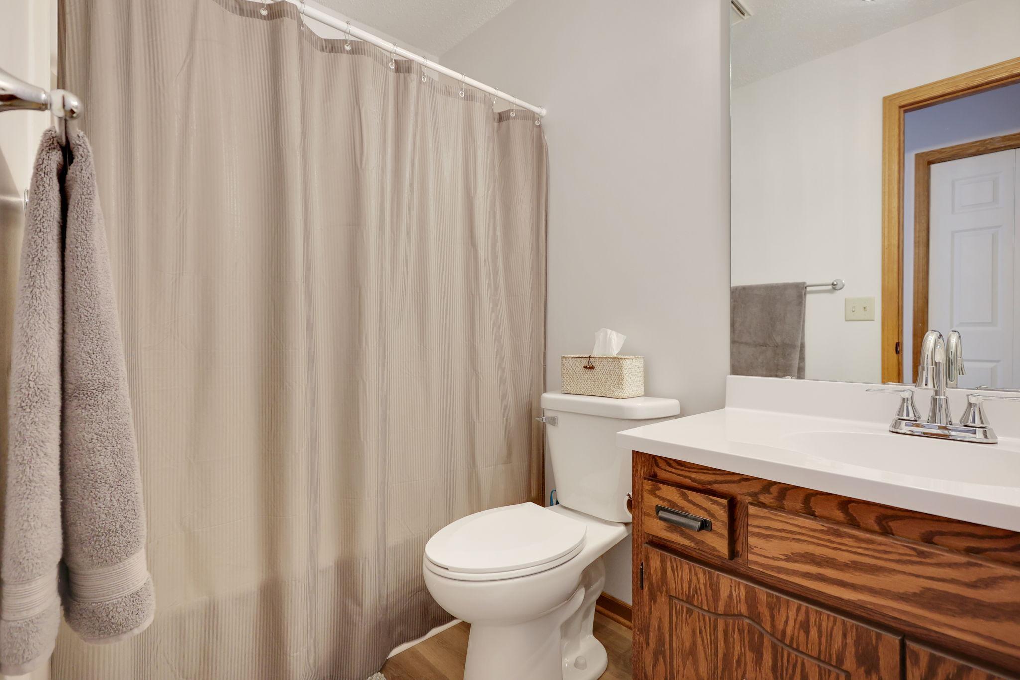 Quest bathroom with updated counters, flooring, toilet, lighting and fixtures