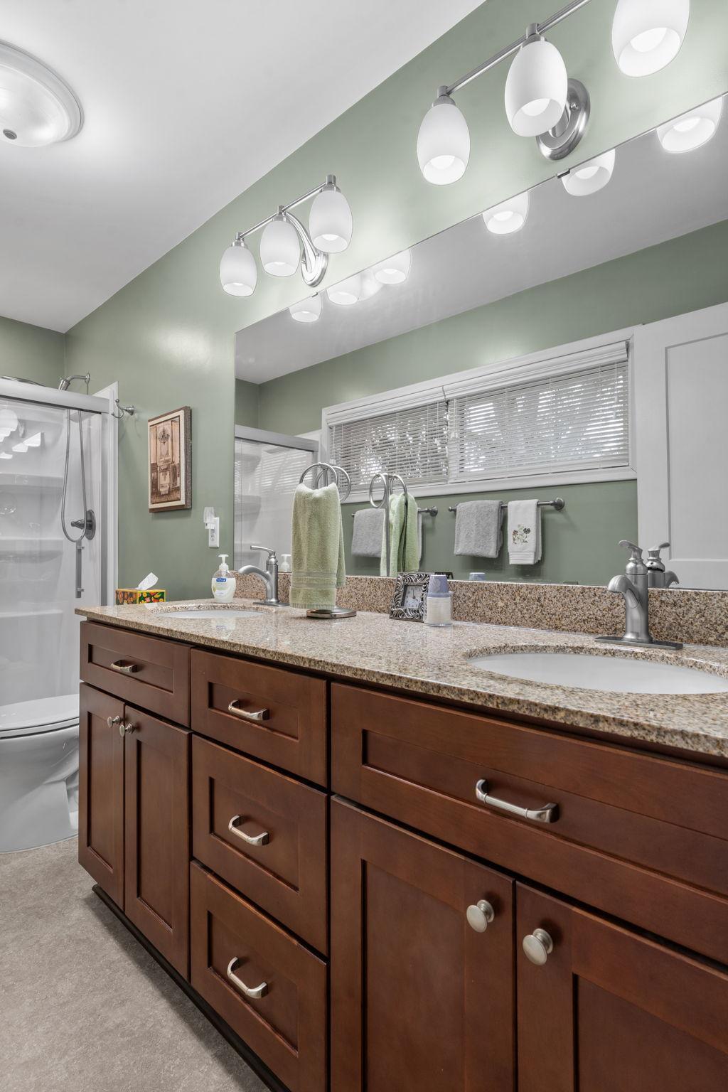 Light and bright with dual sinks and large shower enclosure.