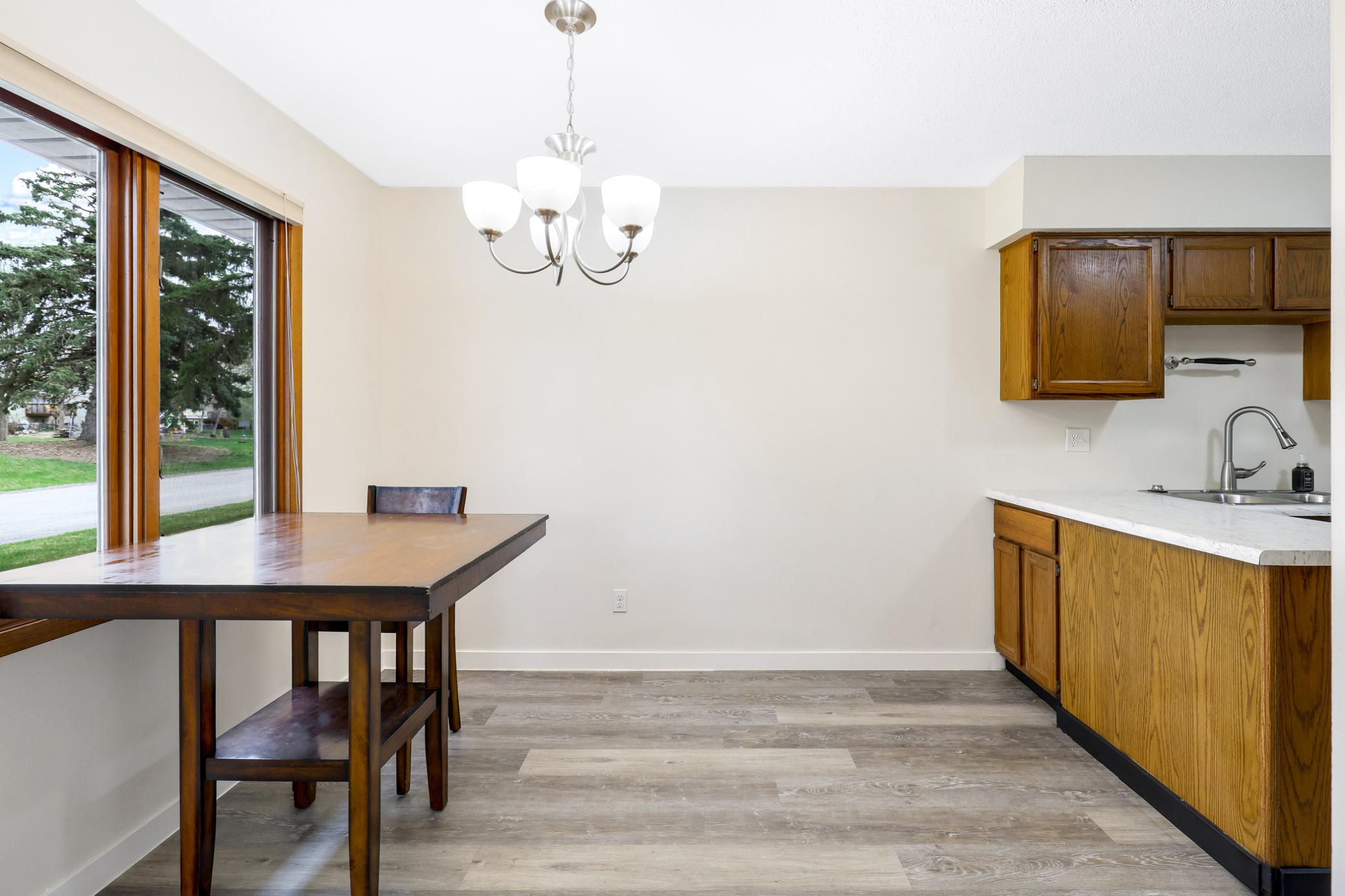 Light-filled dining space with large windows overlooking green space—perfect for everyday meals or hosting with a view.