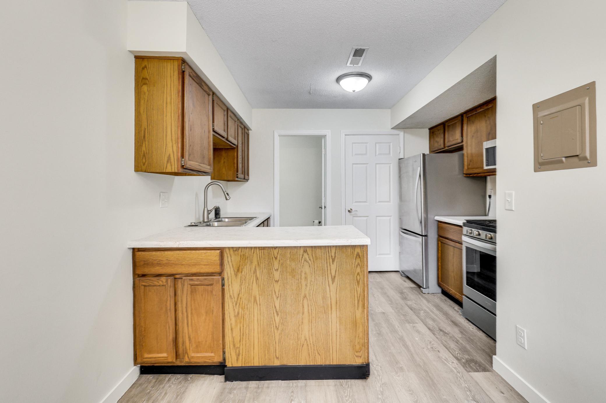 Bright and functional kitchen featuring updated countertops, warm wood cabinetry, stainless steel appliances, and great prep space.