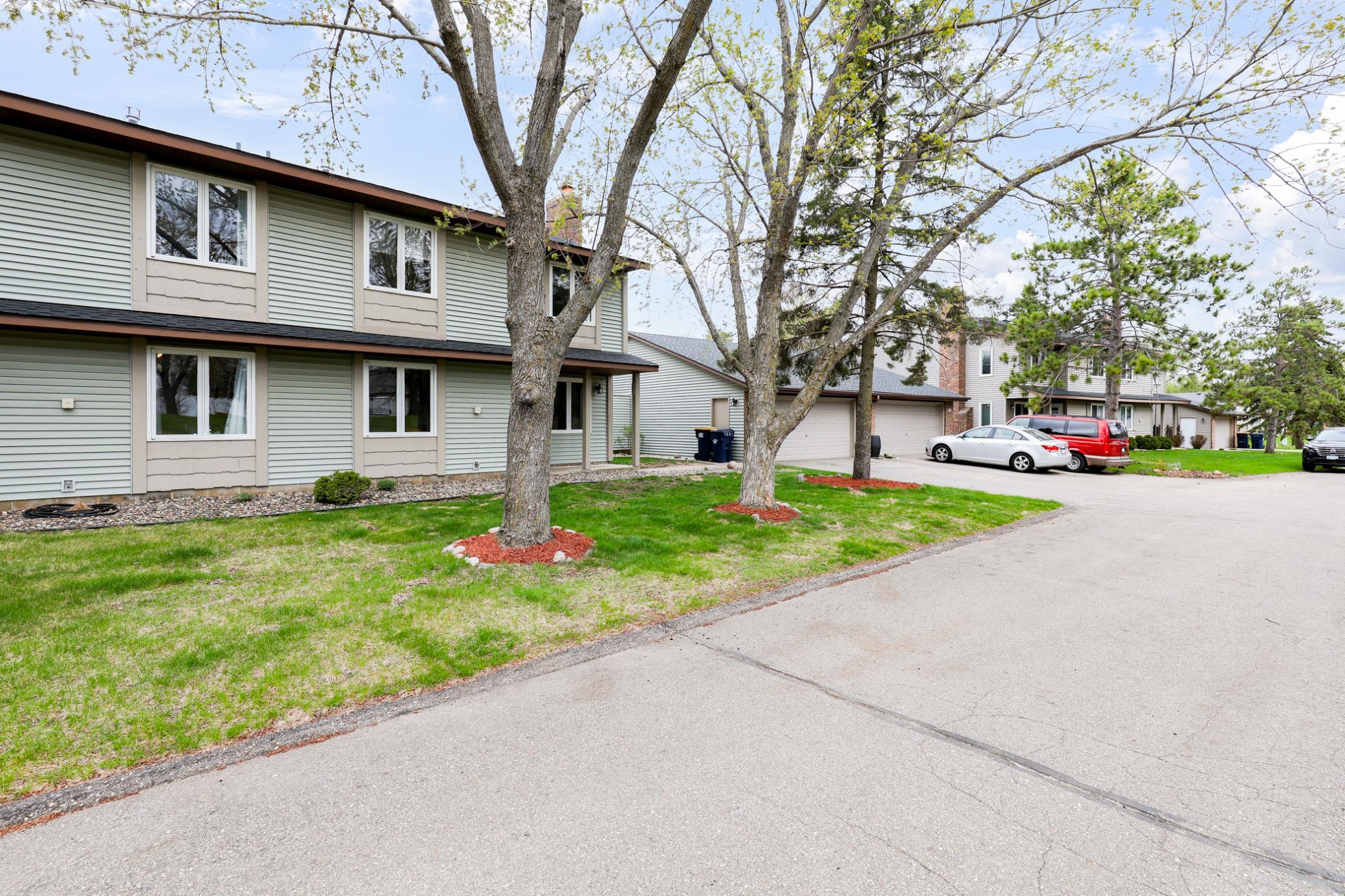 Charming end-unit townhome with mature trees, welcoming curb appeal, and a private setting. Includes a detached 2-car garage and association-maintained exterior for easy living.