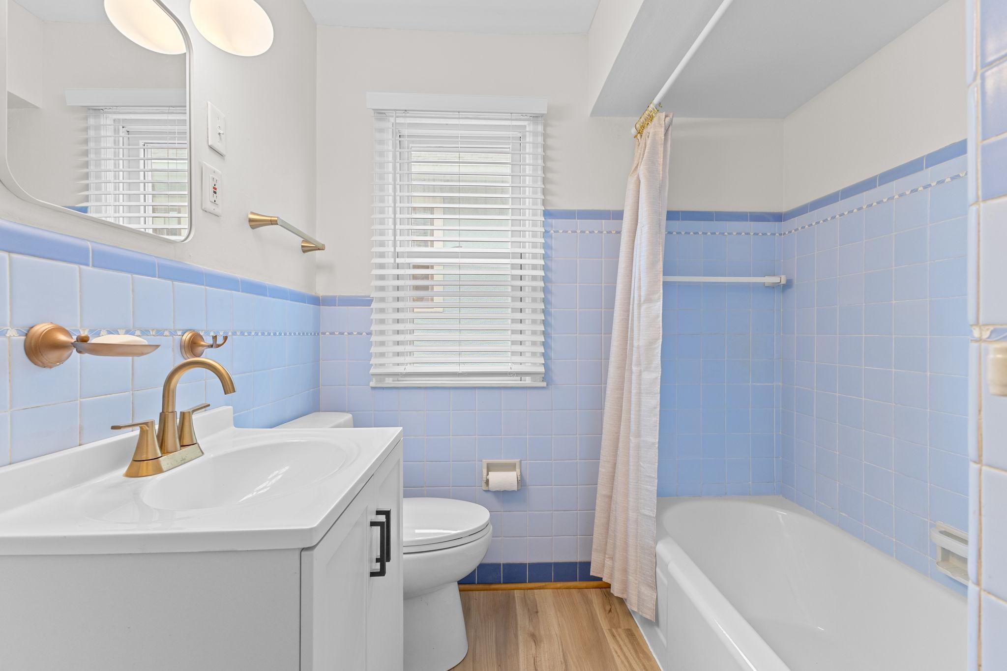 Sleek white vanity, gold hardware, and updated lighting are all features you’re sure to love!