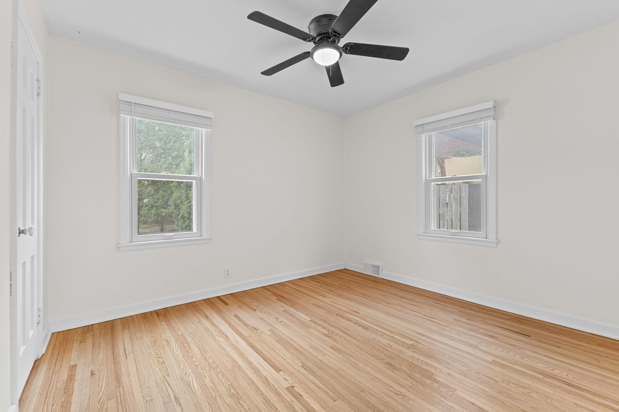 Second main floor bedroom also with hardwood floors and a ceiling fan for added comfort year round!