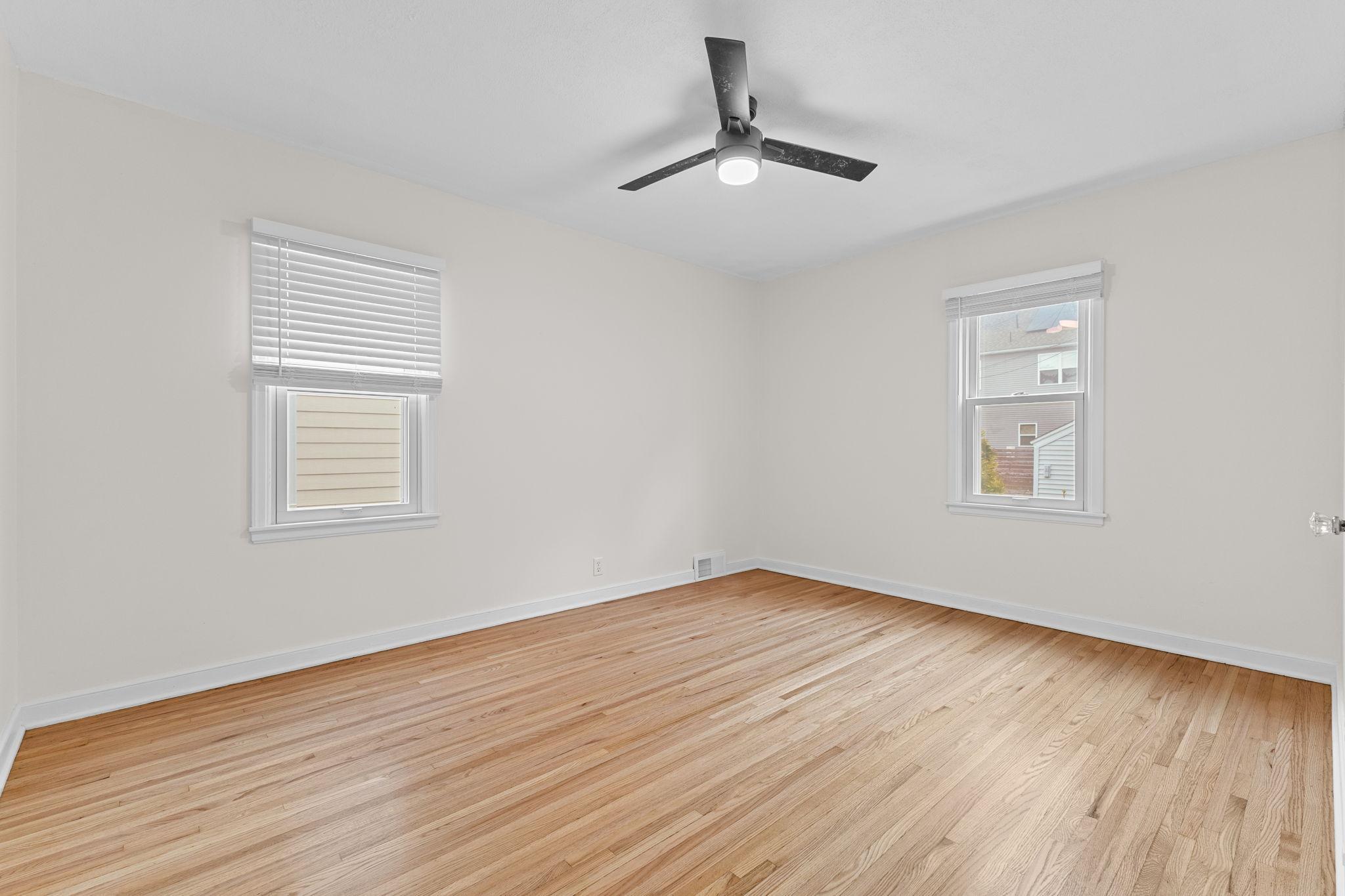 First main floor bedroom boasts hardwood floors, neutral tones, and dual windows!