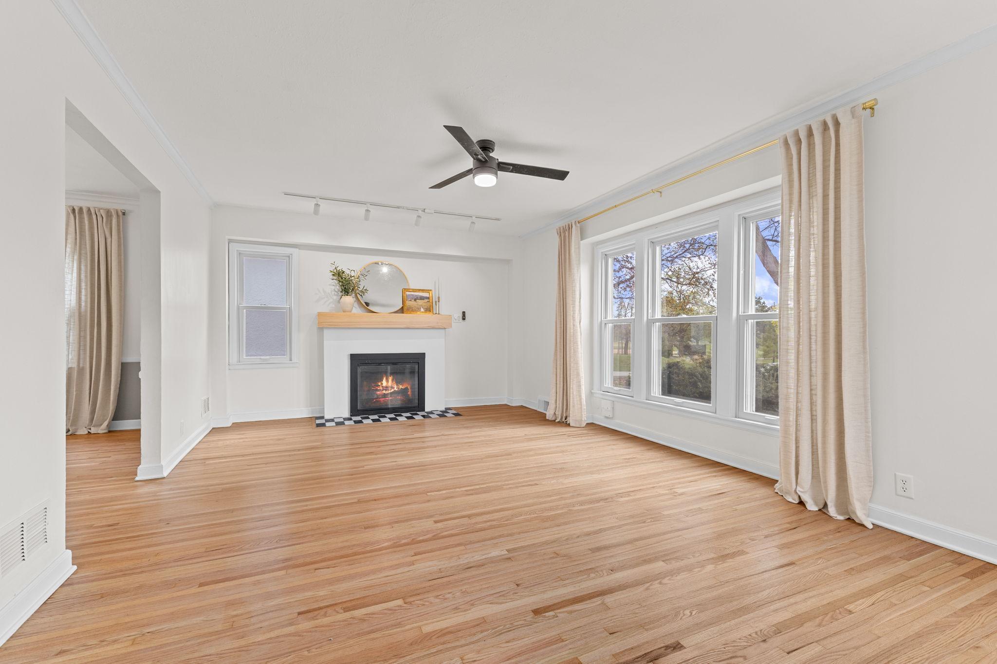 The main level features carefully refinished hardwood floors, neutral tones, and abundant natural light pouring in through large windows.