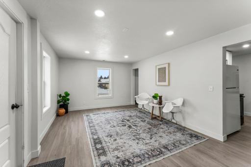The inviting living room is filled with natural light and features new LVP flooring throughout, along with all-new energy-efficient windows and recessed lighting on the main level.