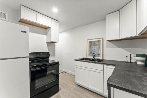 The updated kitchen stands out with sleek new white cabinetry, continuous LVP flooring, and all-new appliances. A spacious 7x3 nook offers the perfect opportunity for a pantry or additional organization.