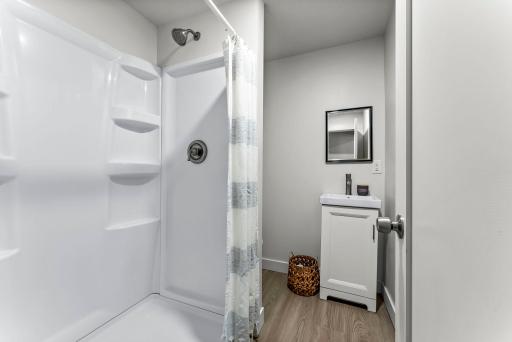 The main-level bathroom has been refreshed with a new walk-in shower, updated plumbing, and a single vanity for storage.