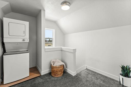 On the upper level, a cozy landing includes a dedicated laundry space that brings extra ease to your everyday routine.