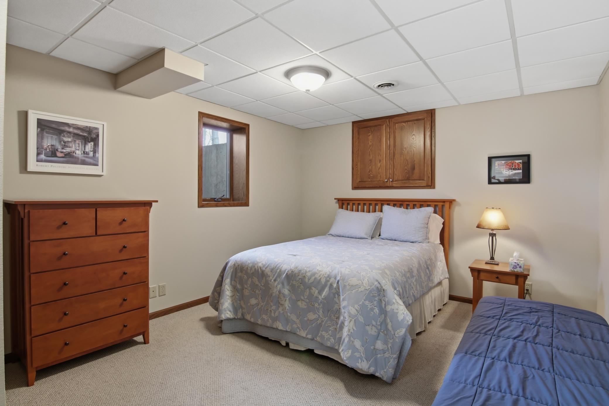 Lower level bedroom. Doors above bed lead to the crawl space under the sunroom ~ perfect for holiday box storage!