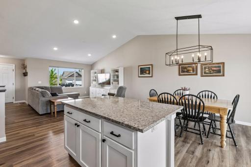Large kitchen island with a granite top has additional storage.