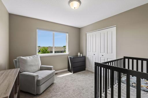 Bedroom is large enough to accommodate a bed and rocker as well as a large closet.