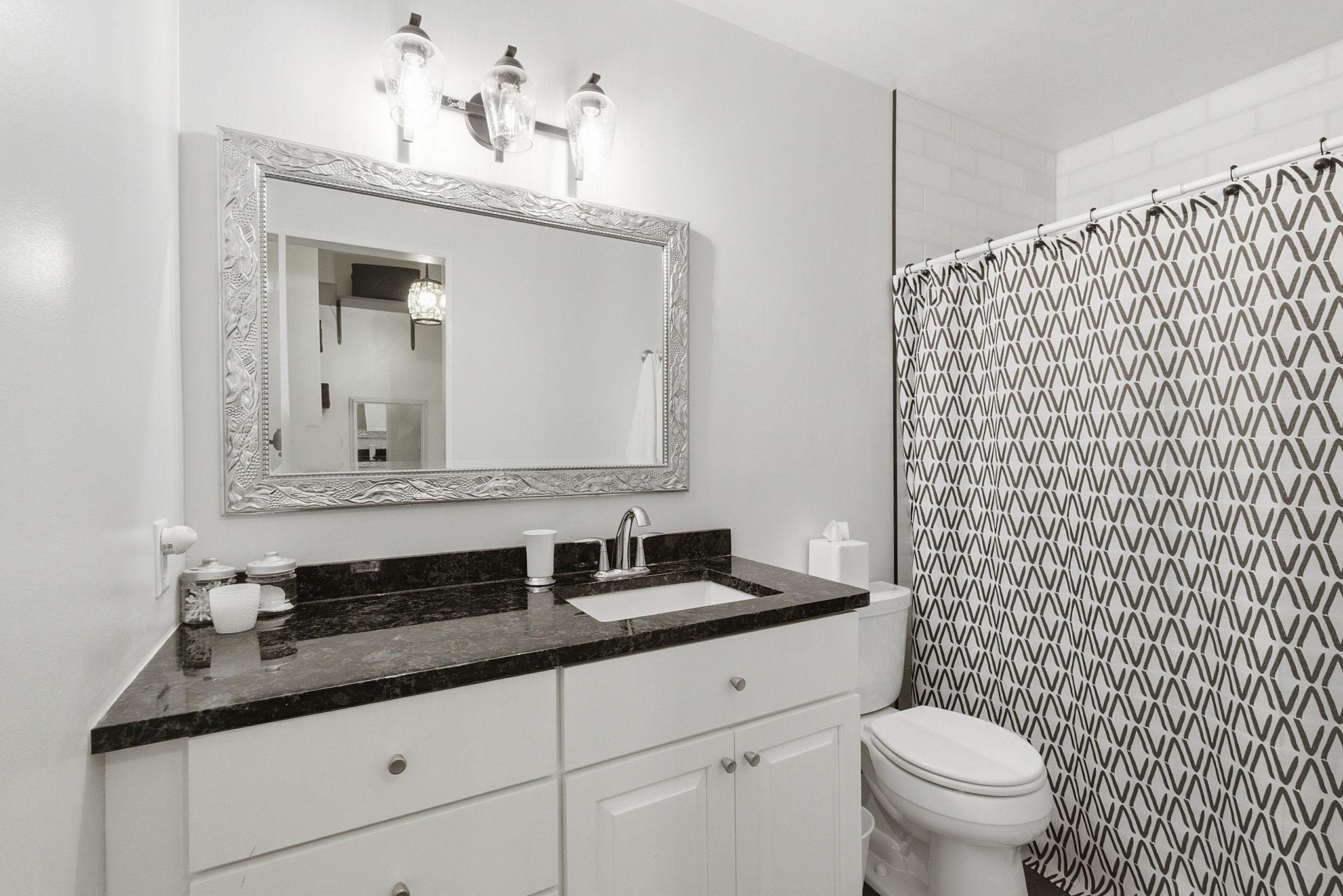 Primary bath with marble tiled shower and dual showerheads