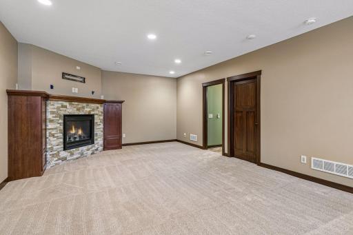 The warm and inviting family room is centered around a striking gas fireplace with stone accents, creating the perfect space to relax while offering plenty of room for multiple seating areas.