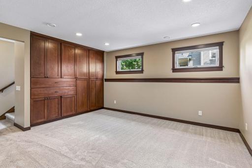 Custom built-in cabinetry provides abundant storage while adding warmth and character to this expansive lower level, making it ideal for organizing games, media, and seasonal dÃ©cor.