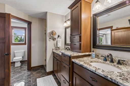 Start each day in style with separate vanities, rich custom cabinetry, heated floors, granite countertops, and a private water closet.