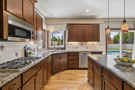 Indoor and outdoor living come together seamlessly. The kitchen opens directly to the backyard oasis, making it effortless to entertain guests or enjoy meals overlooking the pool.