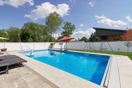 White privacy fence surrounds the backyard.