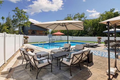 Welcome to your own private resort! This spectacular heated saltwater pool anchors an incredible backyard retreat designed for unforgettable summers with family and friends.