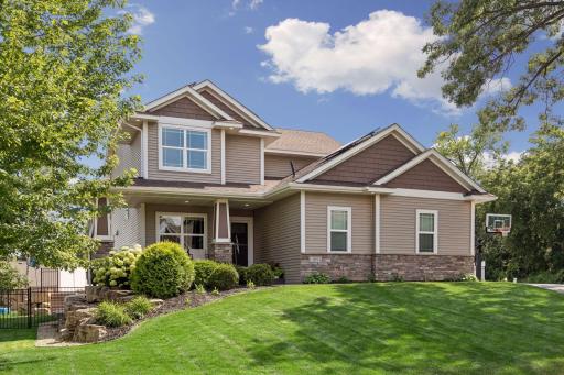 An impressive curb appeal begins with timeless Craftsman-inspired architecture, a welcoming covered front porch, professional landscaping, in-ground sprinkler system, and a mature shade tree that beautifully frames the home on its spacious lot.