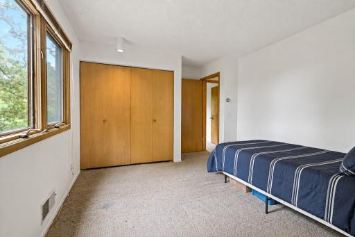 One of the bedrooms on the main level, virtually staged with bedding.