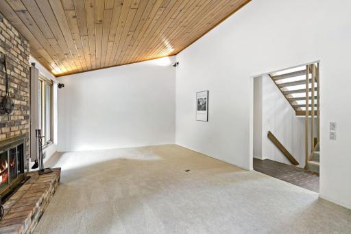 The living room features new carpet and beautiful natural lighting. TV has been virtually removed.