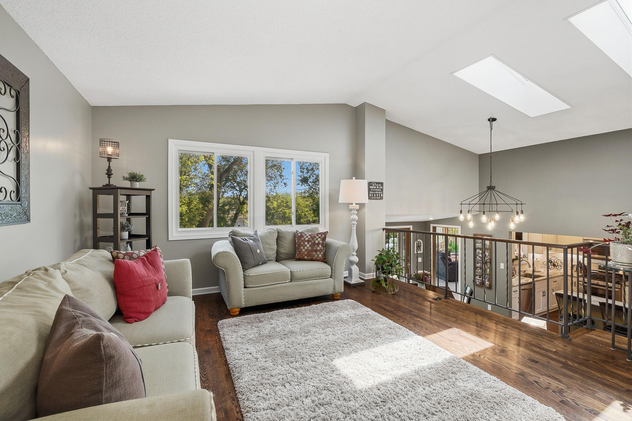 Upper level living room offers gorgeous wood flooring, neutral paint and a bright space..