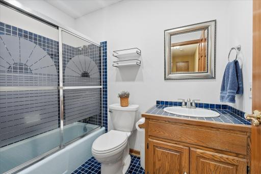 Upper level Full bathroom with tile top vanity, tile floors and updated faucet and light