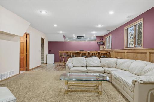 Awesome lower level Amusement Room w/custom wet bar w/ice maker + tile floor, recessed LED can lighting, updated neutral carpet and lookout windows for plenty of natural light