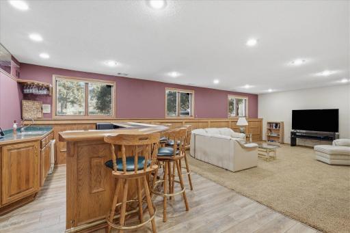 Awesome lower level Amusement Room w/custom wet bar w/ice maker + tile floor and built-in glasses rack. Other features: raised oak panel accent wall, recessed LED can lighting, updated neutral carpet and lookout windows for plenty of natural light