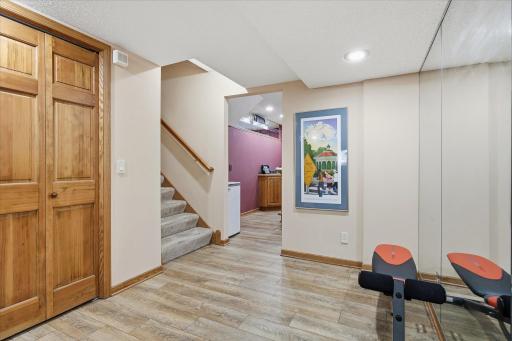 Lower level exercise room Area with tile floor, mirror accent walls and large closet storage space