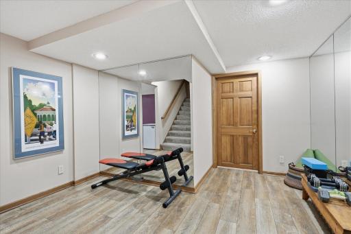 Lower level exercise room Area with tile floor, mirror accent walls and large closet storage space