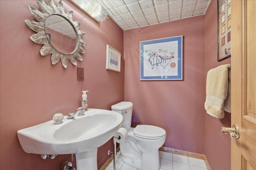 Convenient lower level Half Bathroom with pedestal sink and tile flooring