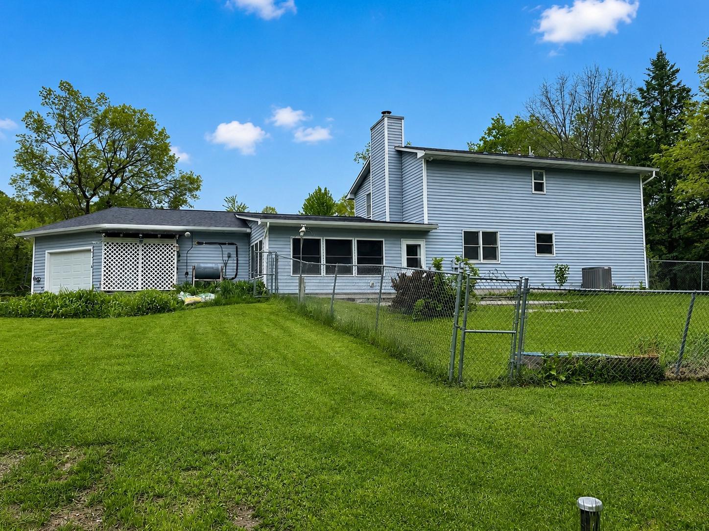 Outdoors, the property continues to impress with open green space, mature trees, and fenced areas for pets or play