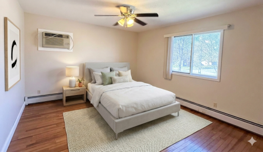 Primary bedroom with ceiling fan and personal a/c unit (virtually staged)