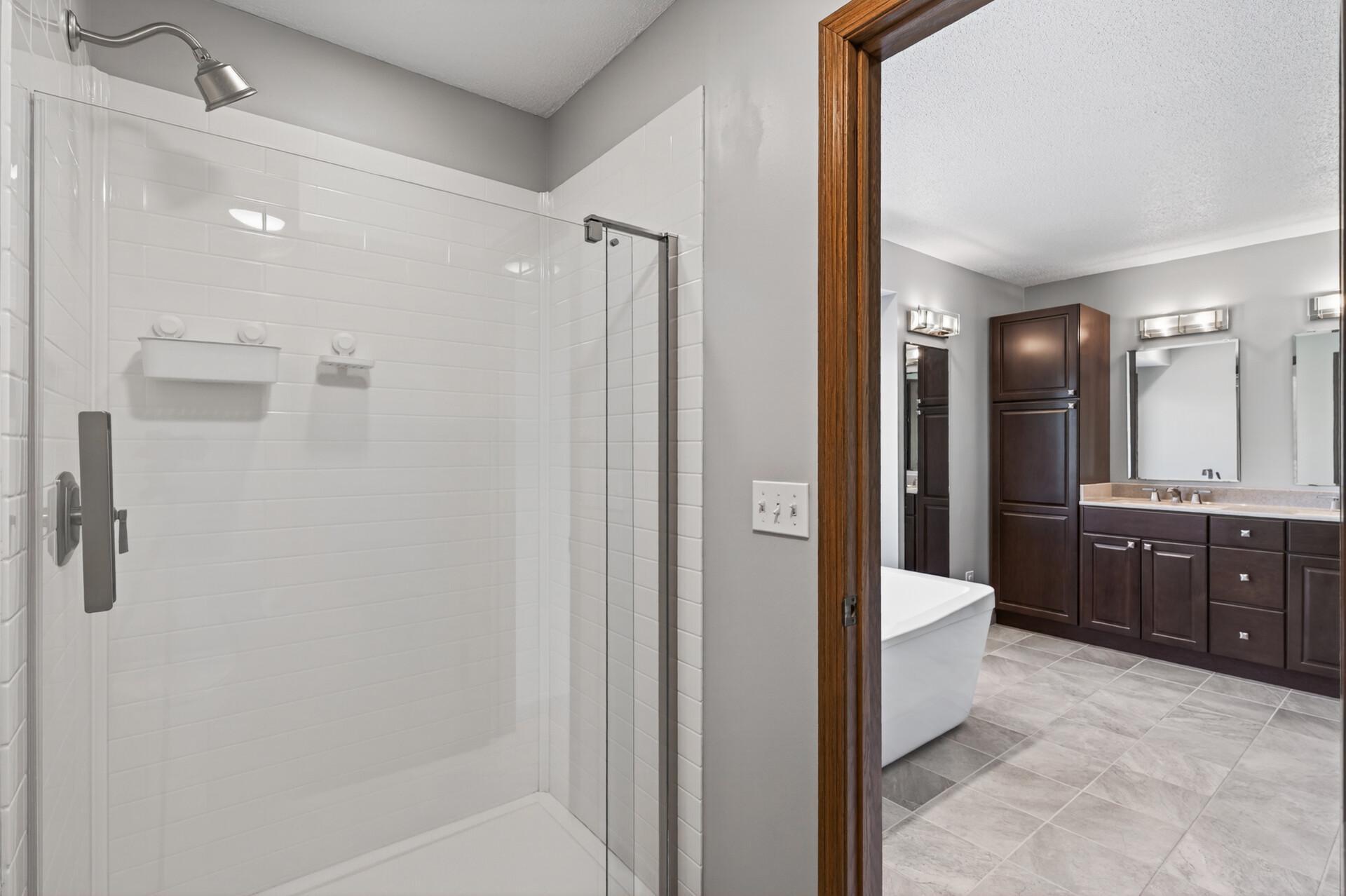 Another room within the primary bathroom suite hosts the walk-in shower and toilet.