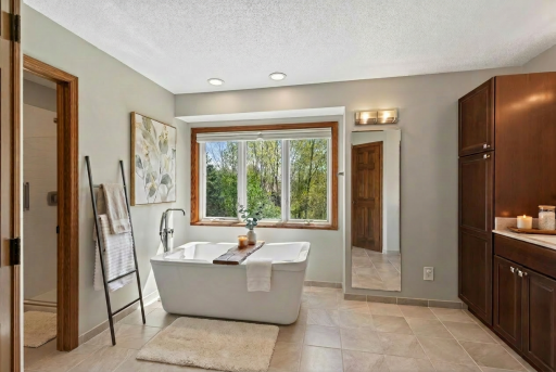 Virtually staged private primary bathroom on upper level.