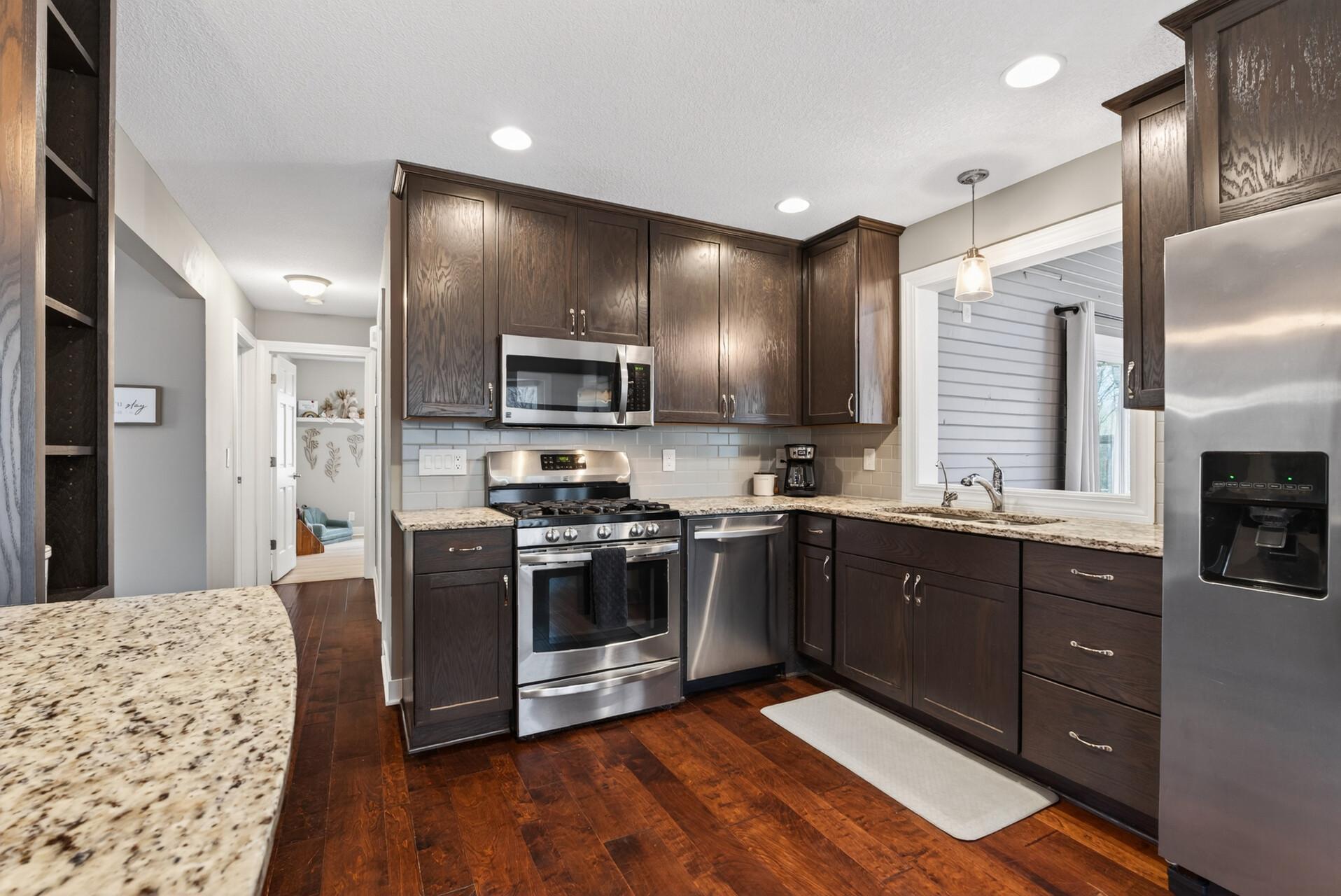 Updated Kitchen with Granite counters, stainless appliances and large kitchen island.
