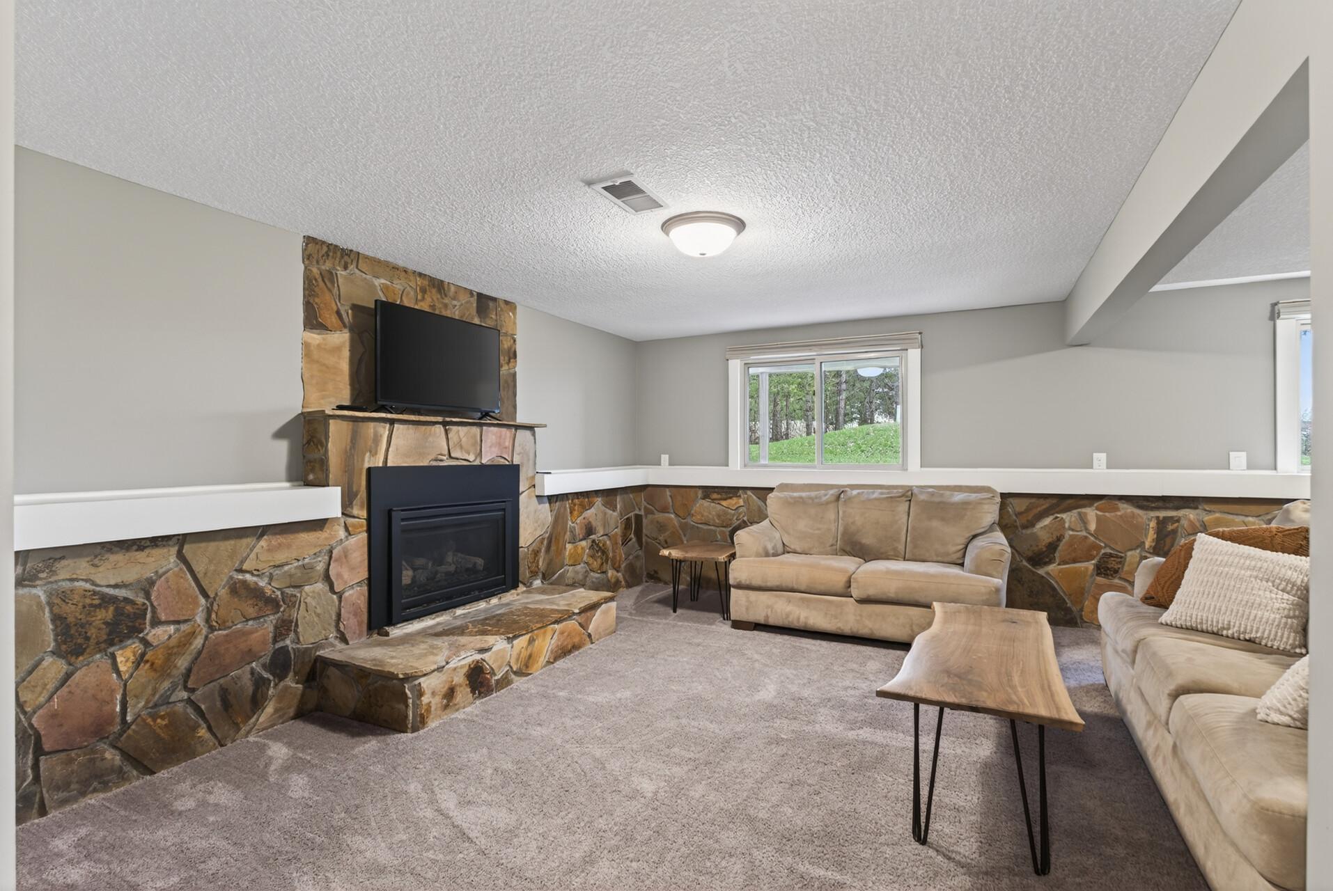 Decorative Stone Gas fireplace in the lower level living room