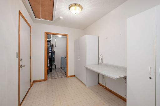 A convenient laundry with a utility sink, storage room and pull-down stairs for storage